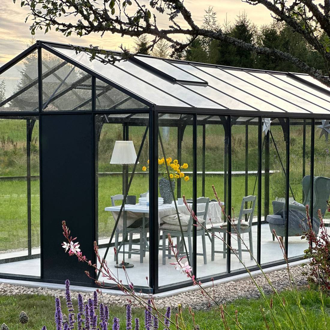 Completed Bloomcabin greenhouse in a landscaped outdoor setting