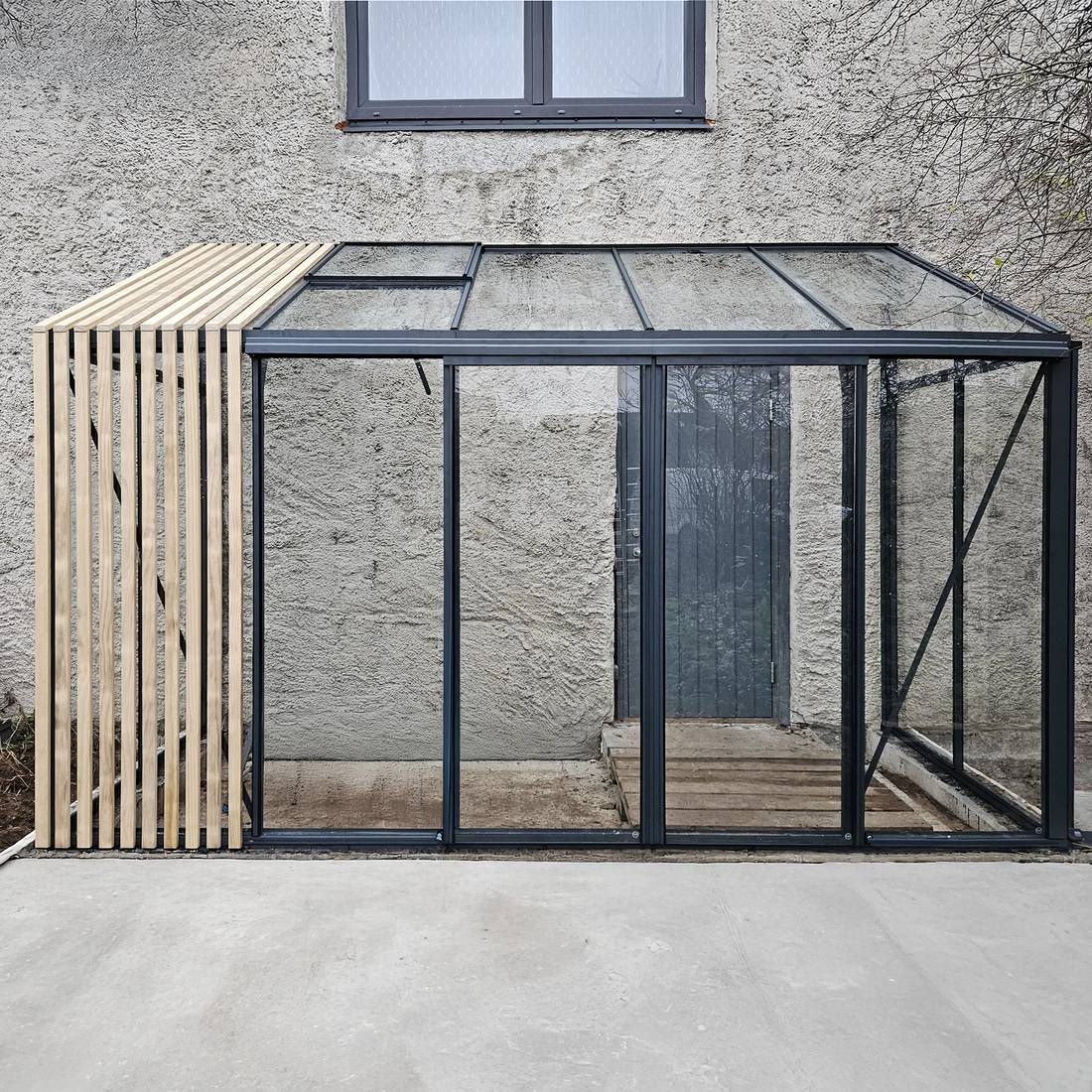 Bloomcabin lean-to greenhouse beside a building